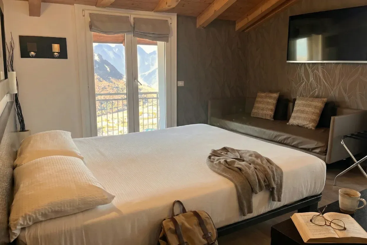 Il letto sotto le travi e la finestra sulle montagne