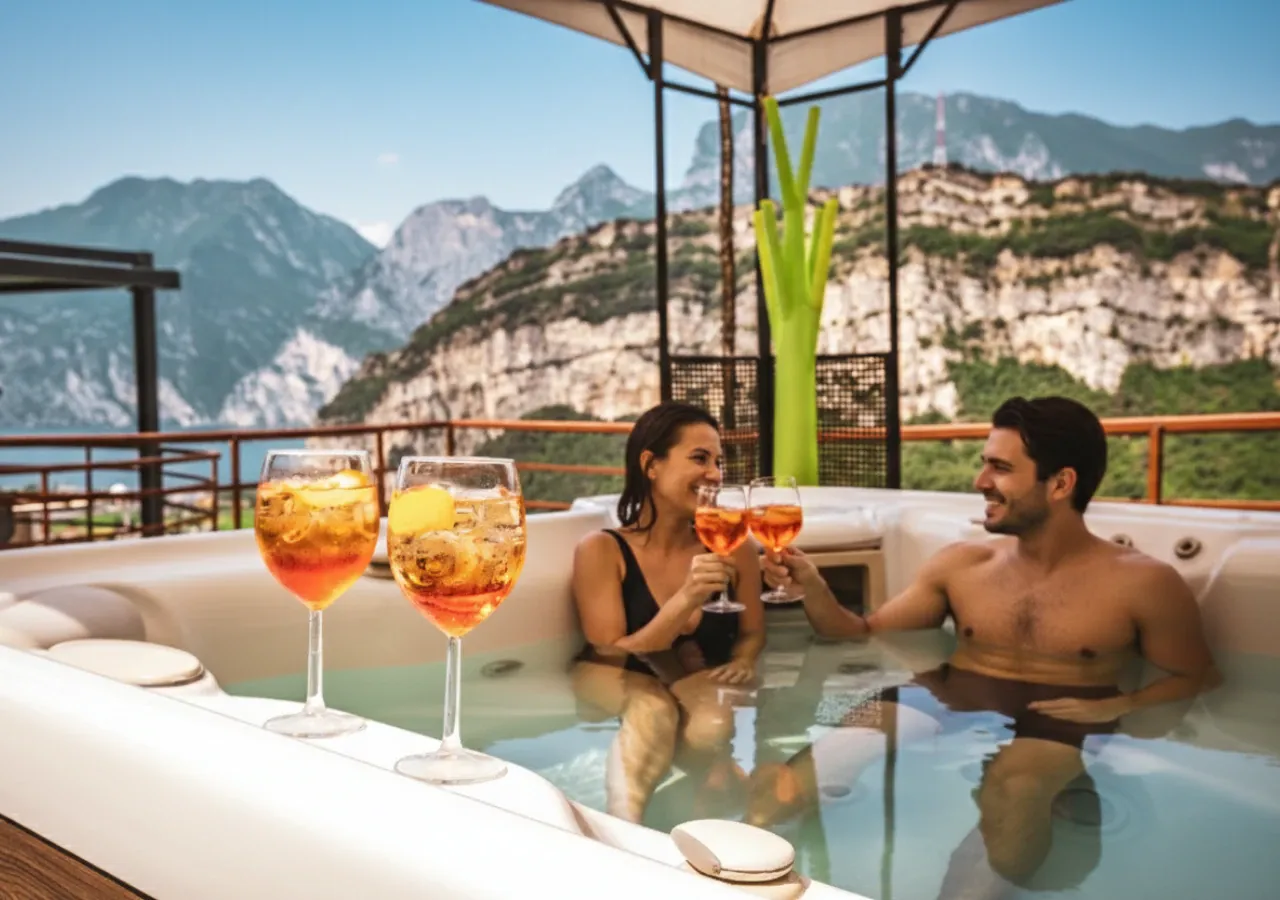 Una coppia brinda nella jacuzzi in giardino, con le montagne