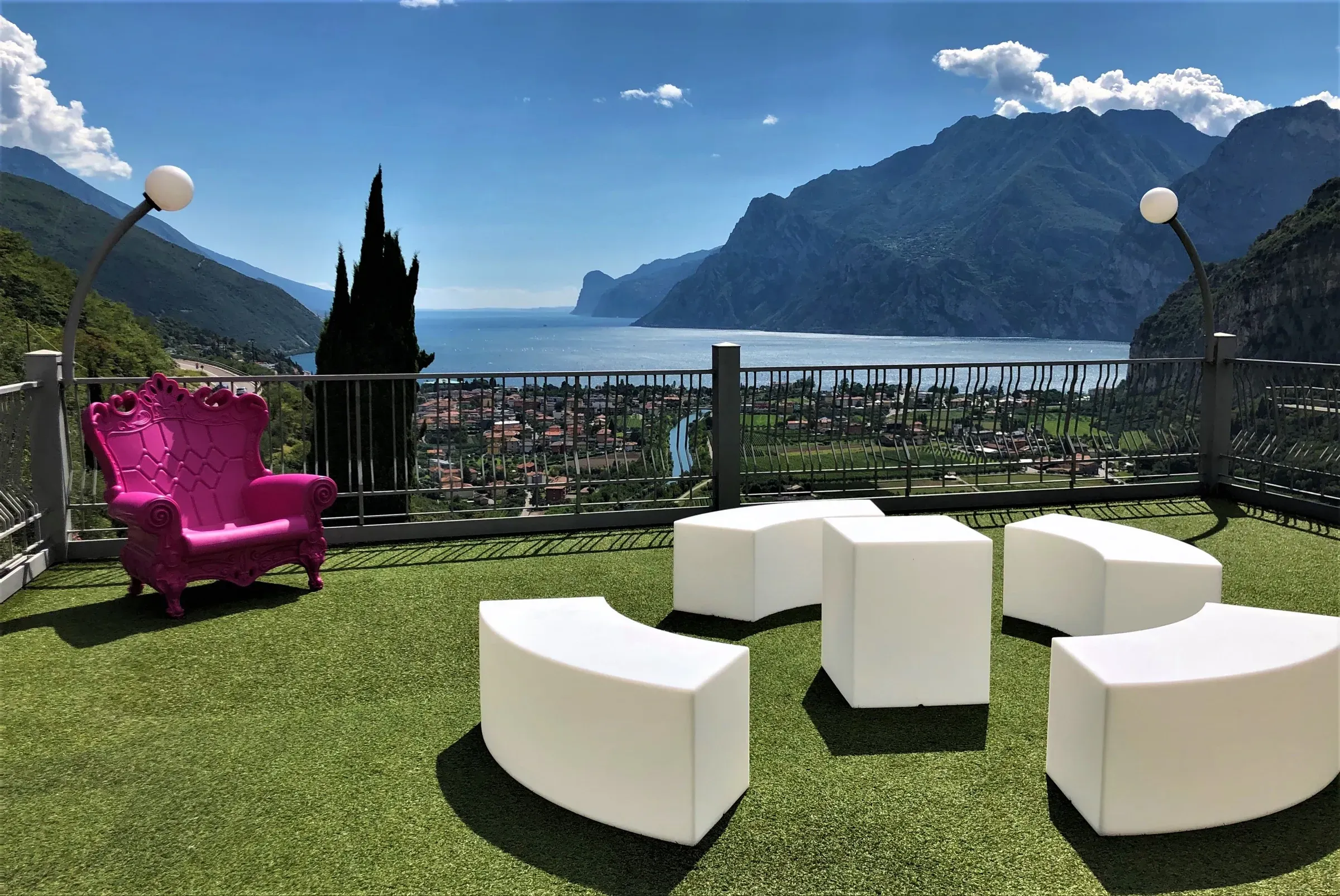 La terrazza panoramica con la poltrona fucsia e i pouf bianchi